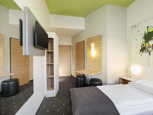a hotel room with a bed and a flat screen tv at B&B HOTEL Berlin-Potsdamer Platz in Berlin