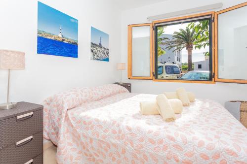 Un dormitorio blanco con una cama y una ventana. en Apartamento en Arenal en Castell, en Arenal d'en Castell