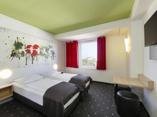 a hotel room with two beds and a window at B&B HOTEL Berlin-Potsdamer Platz in Berlin