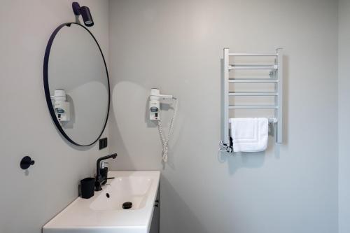 a white bathroom with a sink and a mirror at RixStay Apartments in Rīga