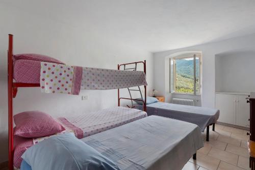 Un dormitorio con dos literas y una ventana. en Casa Luciana Castelnuovo, en Castelnuovo Magra