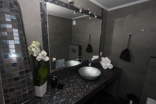 a bathroom with a sink and a mirror at Caldera's Majesty in Imerovigli