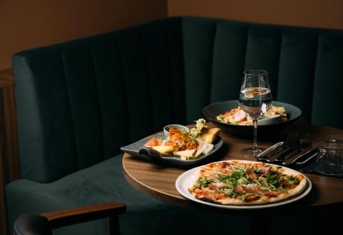 a table with two plates of food and a glass of wine at Bø Hotel in Bø
