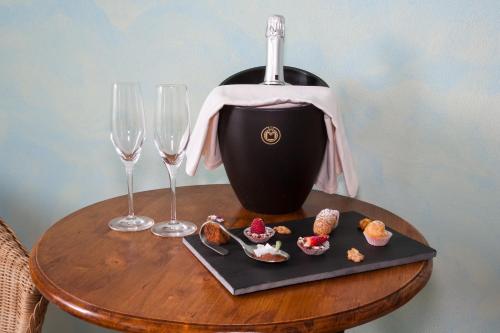 a table with two wine glasses and a plate of food at Locanda Chi Ghinn in Verbania