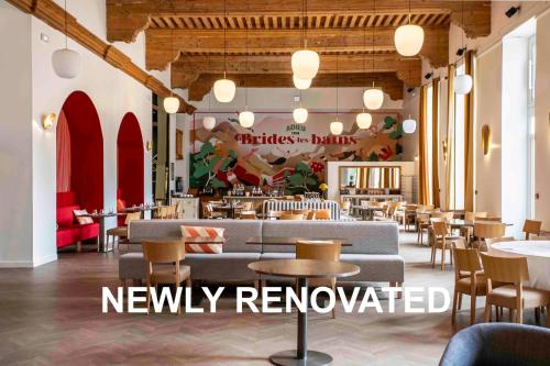 a restaurant with tables and chairs and a new formally renovated at B&B HOME Brides-les-Bains Les 3 Vallées in Brides-les-Bains