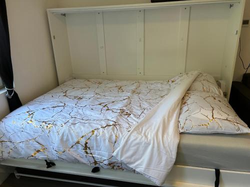 a bed in a room with white walls at Vlinder 2pers studio in Utrecht