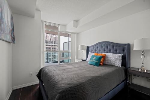a bedroom with a large bed and a window at Autumnaly Whisper 2 BR & DEN in the Heart of the City in Toronto