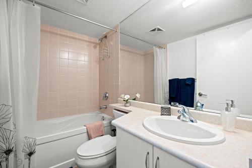 a bathroom with a sink and a toilet and a tub at Autumnaly Whisper 2 BR & DEN in the Heart of the City in Toronto