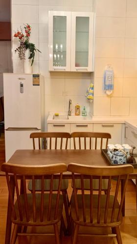 a kitchen with a table and chairs and a refrigerator at Beijing city center - Cosy family suite with city view in Beijing