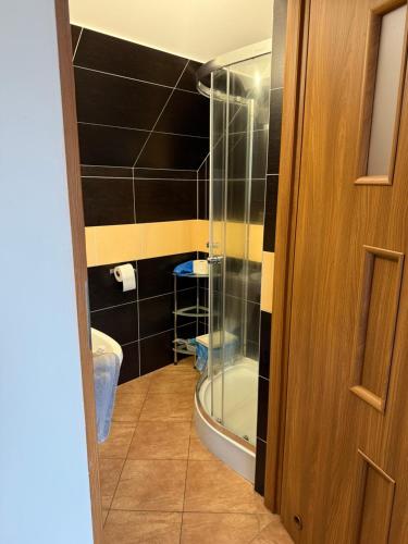 a bathroom with a shower and a glass door at VITA Augustów in Augustów