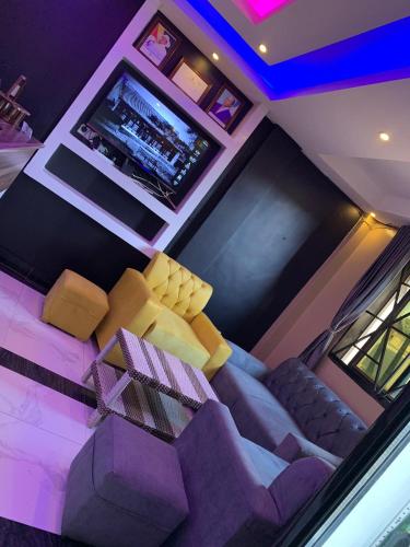 a living room with a couch and a tv at SPOTLIGHT MOTEl in Kampala