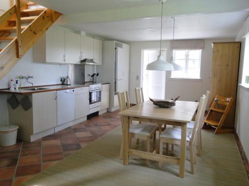 een keuken en eetkamer met een houten tafel bij Dyssegaard Holiday Apartment in Skallerup