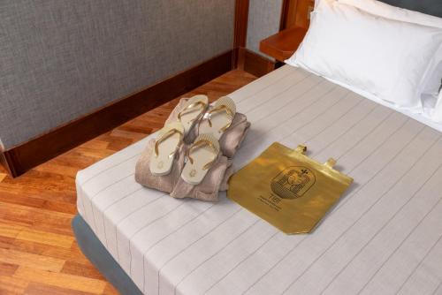 a bed with two shoes and a bag on it at Grand Hotel Duca D'Este in Tivoli Terme