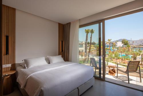 a bedroom with a bed and a balcony with a view at Gouves Waterpark Holiday Resort in Gouves