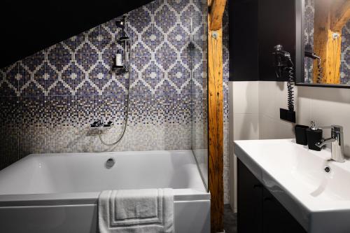 a bathroom with a white tub and a sink at RixStay Apartments in Rīga