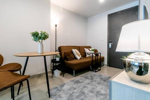 a living room with a couch and a chair and a table at TC Contel at Bts Samrong in Ban Khlong Samrong