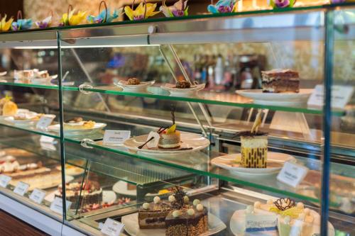 a display case filled with different types of desserts at Hotel Livada Prestige - Terme 3000 - Sava Hotels & Resorts in Moravske Toplice