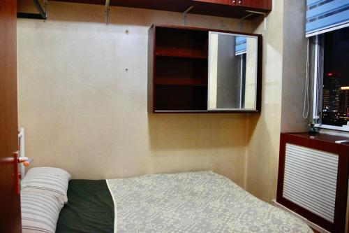 a small bedroom with a bed and a window at Beijing city center - Cosy family suite with city view in Beijing