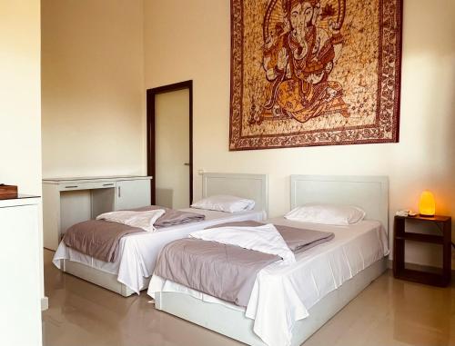 two beds in a room with a painting on the wall at The Wind Farm in Dahab