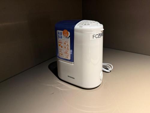 a white cooler with a blue top sitting on a counter at First Cabin Nishi Umeda in Osaka