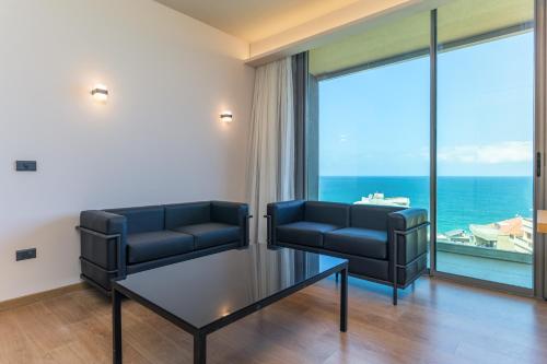 a waiting room with two chairs and a glass table at Jounieh Living - Residences by Local Host in Ed Dkârîne