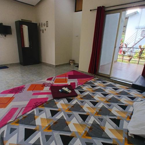 a bedroom with a bed with a colorful quilt on it at Disha Villa in Alibag