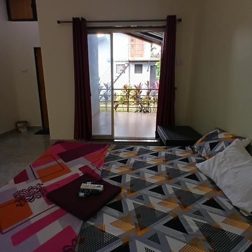 a bedroom with a bed with a colorful quilt at Disha Villa in Alibag