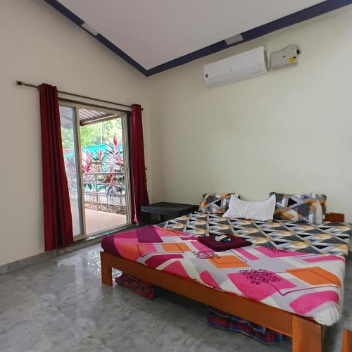 a bedroom with a bed in a room with a window at Disha Villa in Alibag
