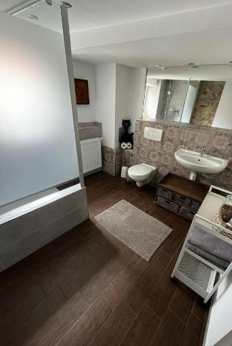 a bathroom with a tub and a sink and a toilet at Haus Buckaroo – Rancho el Rosal in Bad Mergentheim