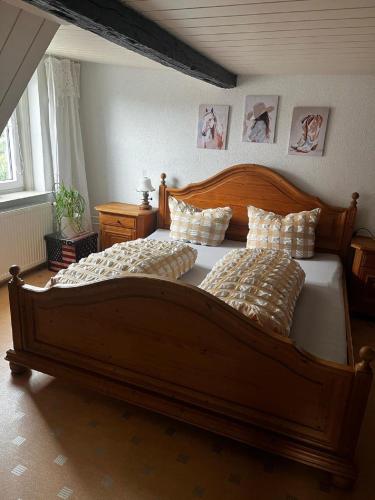 a bedroom with a large wooden bed with pillows at Haus Buckaroo – Rancho el Rosal in Bad Mergentheim