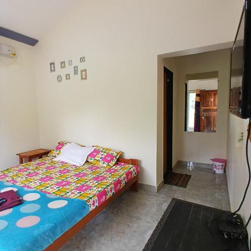 a bedroom with a bed with a colorful comforter at Disha Villa in Alibag
