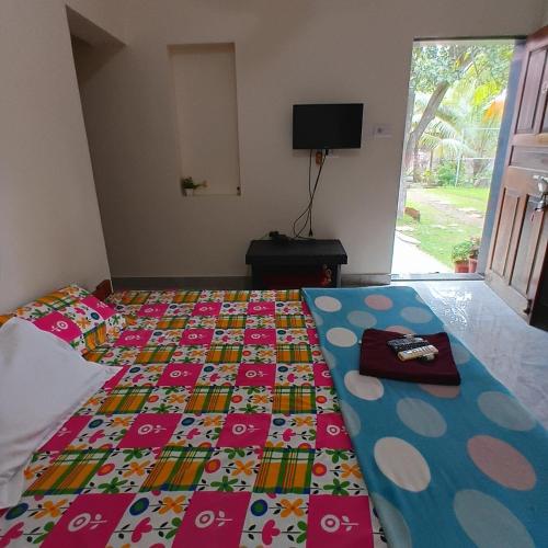 a bedroom with a bed with a colorful quilt on it at Disha Villa in Alibag