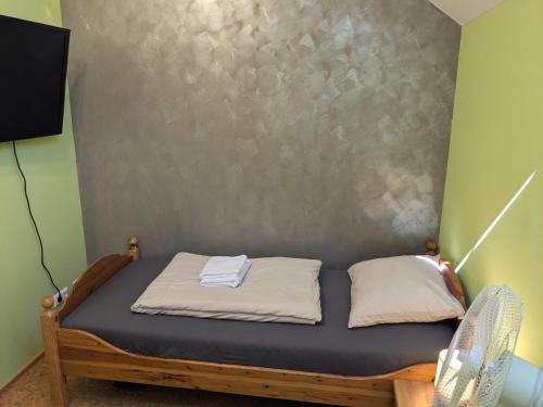 a small bed in a room with a wall at Stop & Sleep - Private Rooms in Ybbs an der Donau