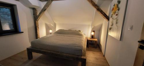 ビスクピエツにあるCiechówka apartamenty Wilimyの小さなベッドルーム(ベッド1台付)が備わる屋根裏部屋です。