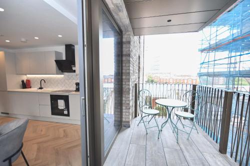 a kitchen and a balcony with a table and chairs at Modern 2 Bed Flat in Central Manchester w Balcony in Manchester
