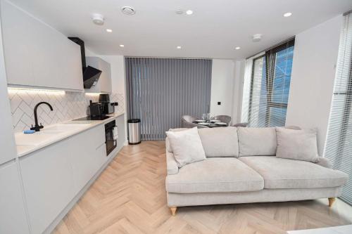 a living room with a couch and a kitchen at Modern 2 Bed Flat in Central Manchester w Balcony in Manchester