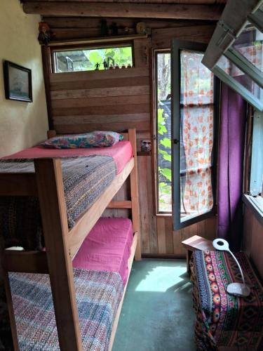a room with two bunk beds and a window at Sigloxx in La Pedrera