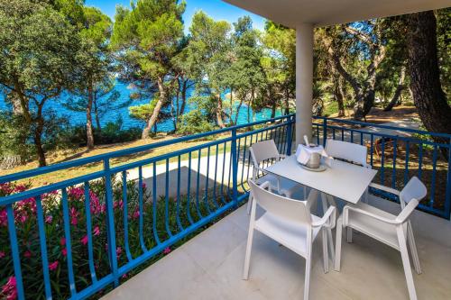 un balcone con tavolo e sedie e vista sull'acqua di Arena Verudela Beach a Pola (Pula)