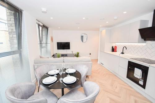 a kitchen and living room with a table and chairs at Modern 2 Bed Flat in Central Manchester w Balcony in Manchester