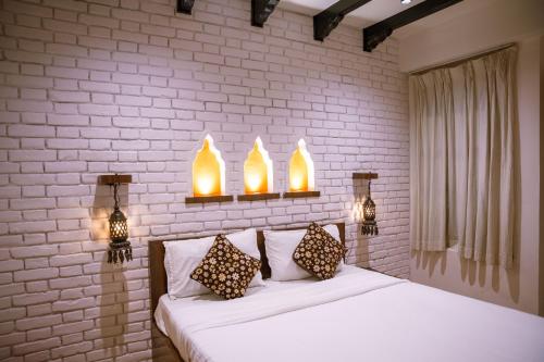 a bedroom with a bed with two lights above it at Nag Pukhu Guest House in Bhaktapur
