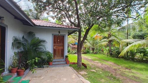 a small white house with a tree in front of it at Disha Villa in Alibag