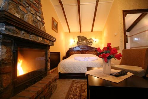 a hotel room with a bed and a fireplace at Patriko Mountain Chalet in Palaios Agios Athanasios