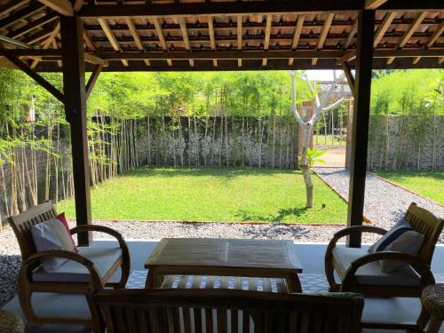 a patio with a table and chairs and a garden at Yukke Tembi Homestay in Yogyakarta