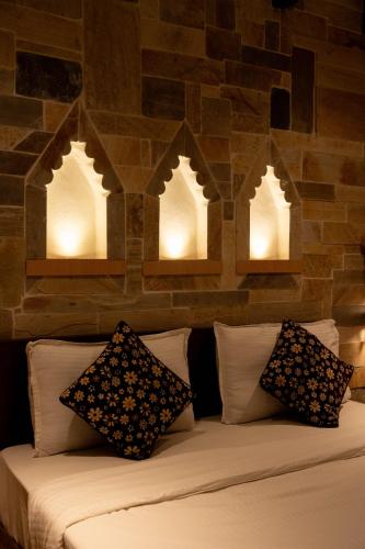 a bed with pillows and lights on a brick wall at Nag Pukhu Guest House in Bhaktapur