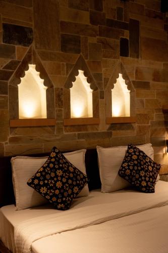 a bed with pillows and lights on a brick wall at Nag Pukhu Guest House in Bhaktapur