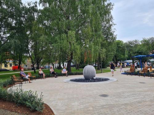 a park with people sitting in chairs and a fountain at Green Villa in Pärnu