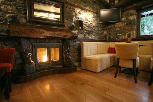 a living room with a couch and a fireplace at Patriko Mountain Chalet in Palaios Agios Athanasios