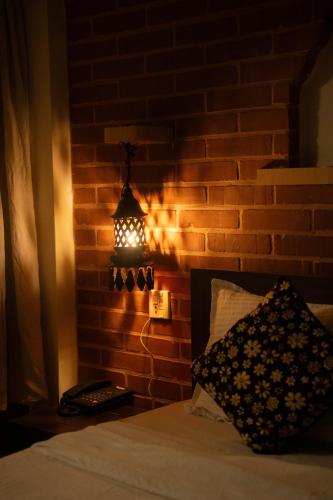 a bedroom with a brick wall with a light on it at Nag Pukhu Guest House in Bhaktapur