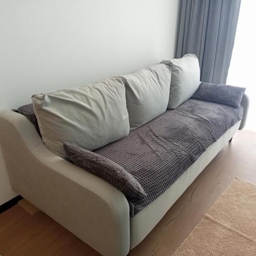a couch with pillows on it in a living room at New apartment near the PALM tree in Uzhhorod