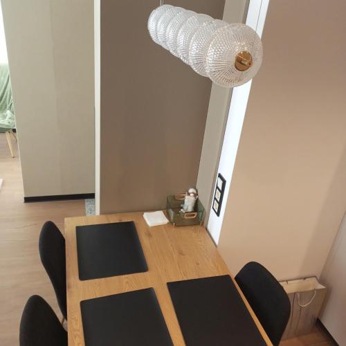 a table with chairs and a light on the ceiling at New apartment near the PALM tree in Uzhhorod